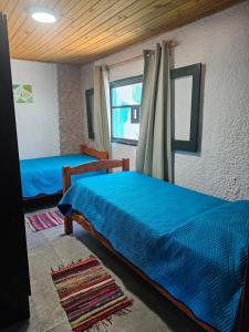 een slaapkamer met 2 bedden en een raam bij Ave Fénix in Aguas Dulces