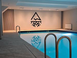 a swimming pool in a hotel with a sign on the wall at Śnieżynka in Szczyrk