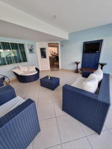 uma sala de estar com cadeiras azuis e um sofá em Zênit Hostel da Cris em Cabo Frio