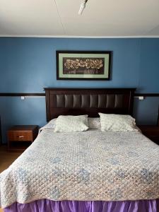 um quarto com uma cama com uma parede azul em Casa central en Punta Arenas em Punta Arenas