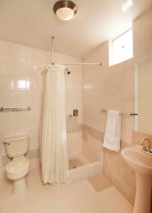y baño con ducha, aseo y lavamanos. en Hotel Benavides, en Arequipa