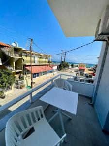 a balcony with a white table and two chairs at Afrodite II in Sarti