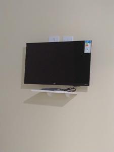 a flat screen tv sitting on top of a wall at Pouso AJH in Paraty