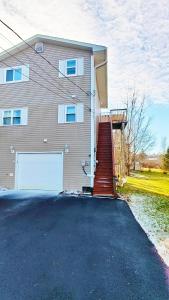 a house with a garage door and a driveway at Fresh & Bright Private Suite in Lower Sackville