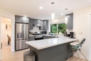 a kitchen with gray cabinets and a white counter top at Cul-de-Sac Comfort BY Betterstay in Bellevue