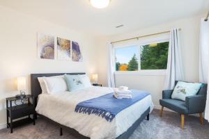 a bedroom with a bed and a chair and a window at Cul-de-Sac Comfort BY Betterstay in Bellevue