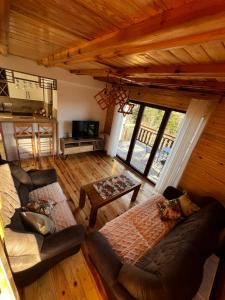 ein Wohnzimmer mit 2 Sofas und einem Tisch in der Unterkunft Brvnara Pogled Zlatara in Nova Varoš