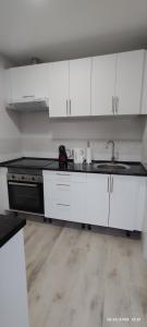 una cocina con armarios blancos y fregadero en Apartamento Agradables 3, en Madrid