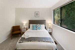a bedroom with a bed and a large window at Highland Haven BY Betterstay in Bellevue