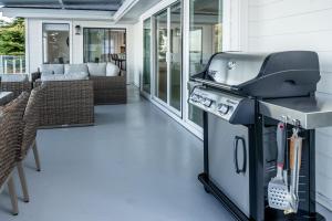 a bbq grill on a porch with a couch at Oceanfront Villa in Ladysmith