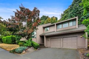 a house with a garage and a tree at Highland Haven BY Betterstay in Bellevue