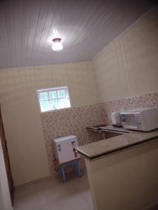 uma cozinha com dois micro-ondas sentados num balcão em Pouso AJH em Paraty