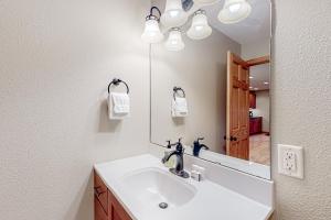 a bathroom with a sink and a mirror at Sunset Ridge Full Property in Manitowish Waters +51 photos