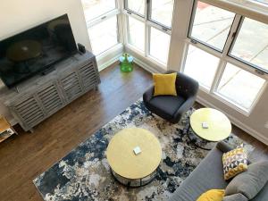 a living room with a television and a couch and chairs at Lincoln Park Light-Filled Loft in Chicago
