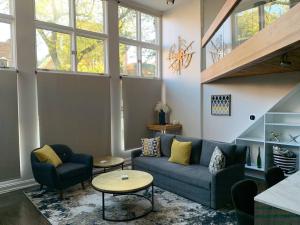 a living room with a blue couch and a table at Lincoln Park Light-Filled Loft in Chicago