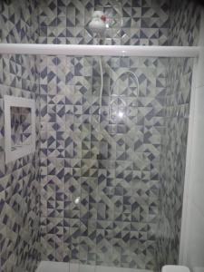 a shower with blue and white tiles in a bathroom at Pouso AJH in Paraty +19 photos