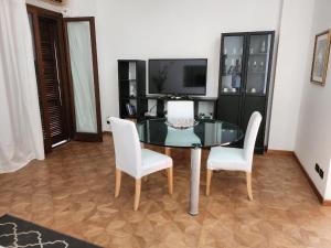 a dining room with a glass table and white chairs at Villa Florencia in Boca Chica