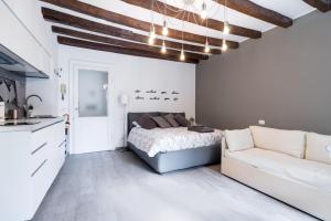 ミラノにあるNavigli - 45 Vigevano & Casale studiosの白いベッドルーム(ベッド1台、ソファ付)