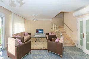 a living room with two couches and a tv at Paradise Town Villa Legend in Belek