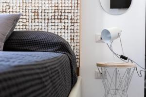 Un dormitorio con una cama y una lámpara sobre una mesa. en Navigli - Vigevano 45 & Casale 3a studios, en Milán