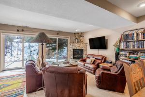 a living room with leather furniture and a fireplace at Eagle River Retreat in Avon