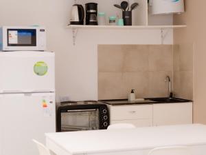 BORGES HOUSE APARTS Aparts con cochera a dos cuadras del obelisco في بوينس آيرس: مطبخ مع موقد وثلاجة