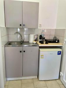 a small kitchen with a sink and a refrigerator at Afrodite II in Sarti