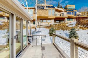 a balcony with a grill and a house at Snowfall Sanctuary, Unit 12 in Vail