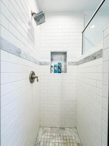 a white tiled shower with two blue toothbrushes at Modern 2-Bedroom Gem Close to Beverly Hills - DOH2 in Los Angeles