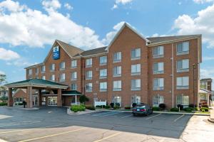 un grand bâtiment en briques rouges avec un parking dans l'établissement Best Western Executive Inn & Suites, à Grand Rapids