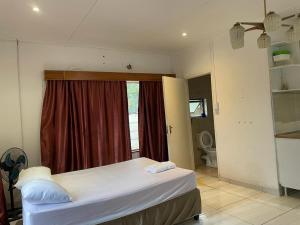 a bedroom with a bed in a room with a window at De la posh Travels and tours in Windhoek