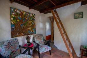 um quarto com duas cadeiras e um quadro na parede em Finca Los Abuelos - La Planta em Concepción