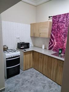 kuchnia z kuchenką i kuchenką mikrofalową w obiekcie Brufut Residence w mieście Brufut
