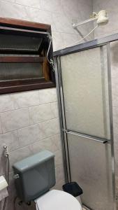 a bathroom with a toilet and a glass shower at LARA'S HOUSE in São Sebastião