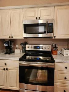 a kitchen with a stove and a microwave at Casita #5 @ Riverhill in Kerrville