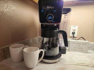 a coffee maker sitting next to two cups on a counter at Casita #5 @ Riverhill in Kerrville