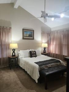 a bedroom with a bed with two lamps and a ceiling fan at Casita #5 @ Riverhill in Kerrville