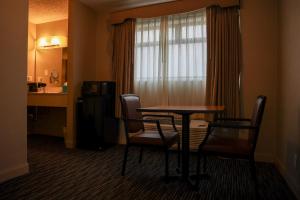 ein Hotelzimmer mit einem Tisch, Stühlen und einem Fenster in der Unterkunft City Center Inn and Suites in San Francisco