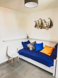 ein Schlafzimmer mit einem blauen Bett mit Kissen und einem Stuhl in der Unterkunft Rivage de Rêve - Hyères Plage in Hyères