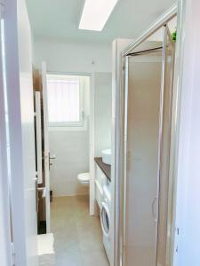 ein Badezimmer mit einem WC und einer Waschmaschine in der Unterkunft Rivage de Rêve - Hyères Plage in Hyères