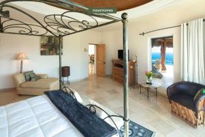 a bedroom with a bed and a living room at Cliffside 8BR Villa with Breathtaking Views - Pool in Cabo San Lucas