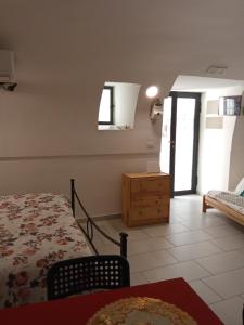 ein Schlafzimmer mit einem Bett, einem Tisch und einer Kommode in der Unterkunft Mary's house in Portici