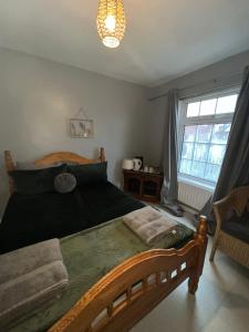 een slaapkamer met een houten bed en een raam bij House near to CastleCourt shopping in Belfast