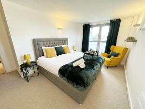 1 dormitorio con 1 cama grande y 1 silla amarilla en Vibrant City Apt 2 Bed in Hoxton and Shoreditch, en Londres