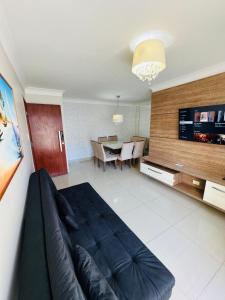 a living room with a couch and a table at Descanso cond edifício tropical B in Maceió