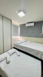 duas camas num quarto de hotel com em Descanso cond edifício tropical B em Maceió