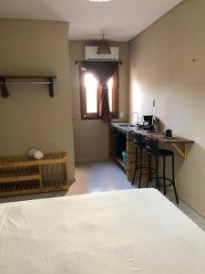 a room with a bed and a kitchen with a counter at Suite Compacta Wind Jeri in Jericoacoara