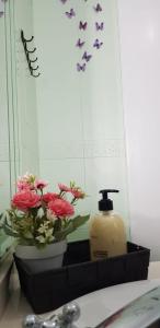 a bathroom sink with a bottle of soap and flowers at Alojamiento Maria in Pinos Genil