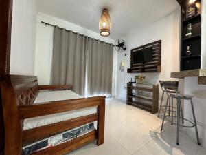een slaapkamer met een bed en een tv in een kamer bij Apartamento da Jana a 1,5km praia in Porto Seguro