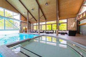 een groot zwembad in een groot gebouw met een zwembad bij Horseshoe Valley Suites - The Verdant in Shanty Bay